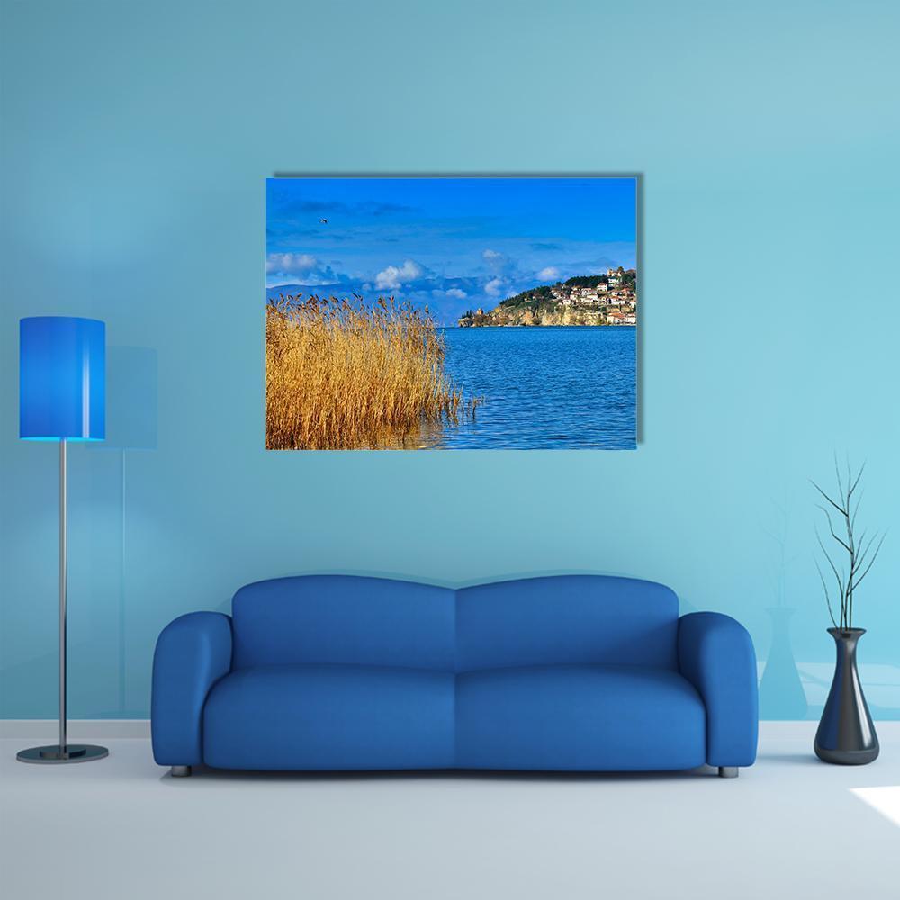 Lake Ohrid Reeds and Mountain Town Canvas Wall Art in brown, yellow and blue, single panel hung on a wall