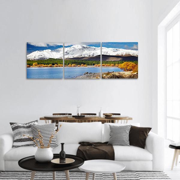 Blue Lake with Snow-capped Peaks Panoramic Canvas Wall Art in white, yellow and blue, hung on a wall