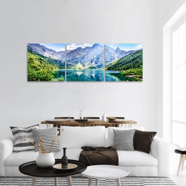Alpine Lake with Jagged Mountain Peaks Panoramic Canvas Wall Art in gray, green and blue, hung on a wall