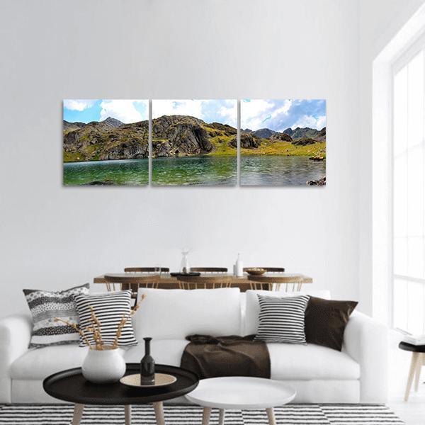Alpine Lake and Mountain Range Canvas Wall Art in brown, green and blue, hung on a wall