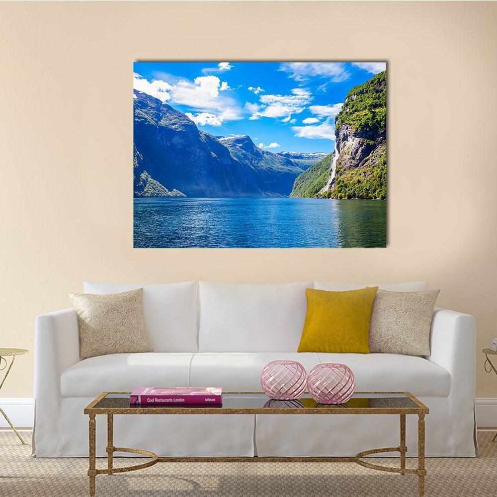 Seven Sisters Waterfall Over Mountain Lake Canvas Wall Art in green and blue, single panel hung on a wall
