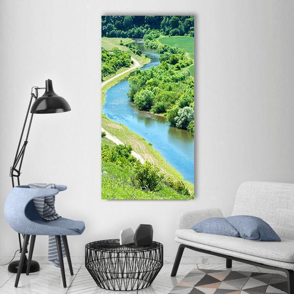 Winding River Through Lush Green Valley Vertical Canvas Wall Art in green and blue, single vertical panel hung on a wall
