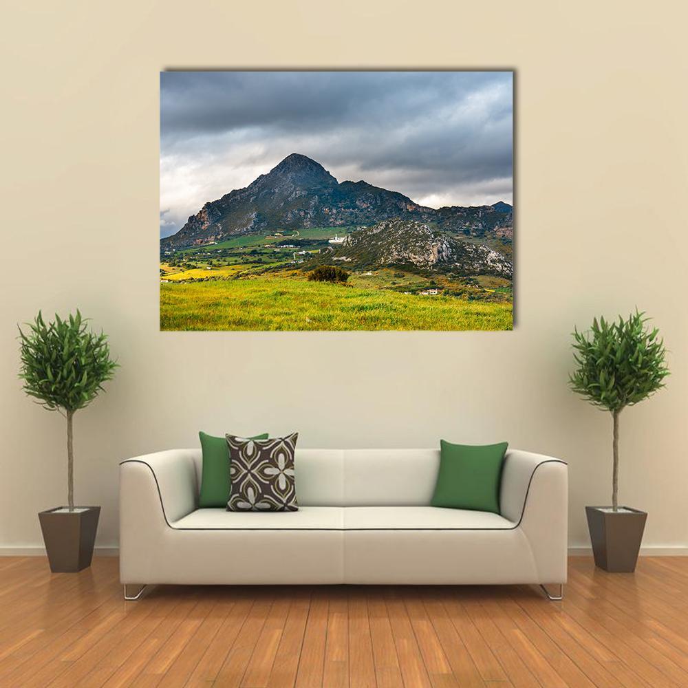 Mountain Village with Stormy Sky Canvas Wall Art in gray, green and blue, single panel hung on a wall