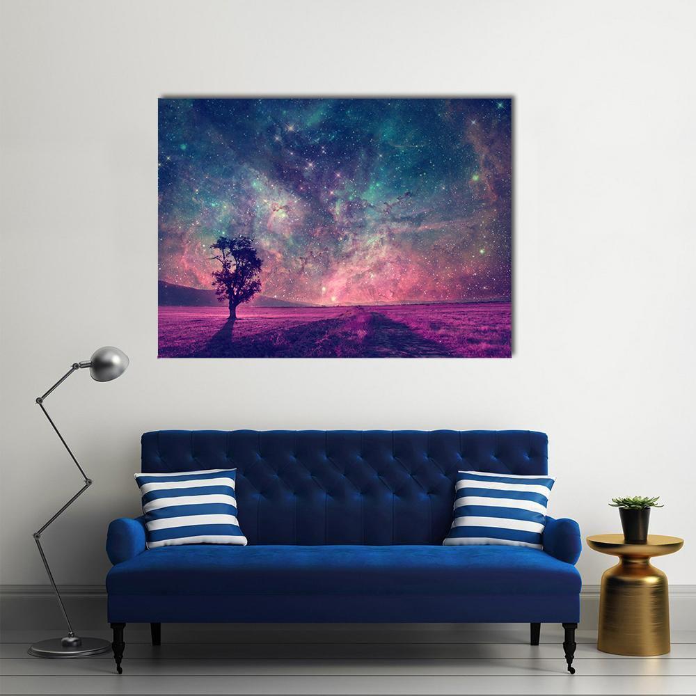 Tree Silhouette Beneath Purple Nebula Sky Canvas Wall Art in blue, purple and pink, single panel hung on a wall