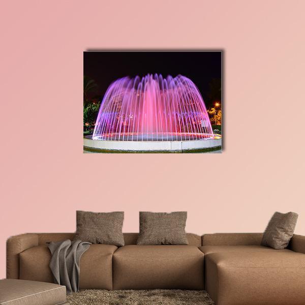 Led Fountain with Pink and Purple Lights Canvas Wall Art in black, purple and pink, single panel hung on a wall