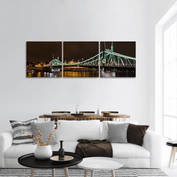 Liberty Bridge Budapest at Night Panoramic Canvas Wall Art in black, yellow and green, hung on a wall