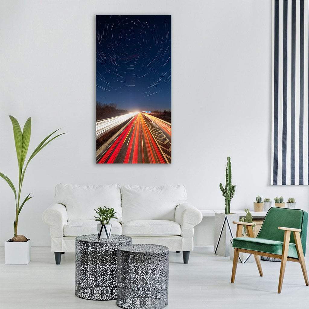 Highway Light Trails Beneath Star Trails Vertical Canvas Wall Art in black, red and blue, single vertical panel hung on a wall