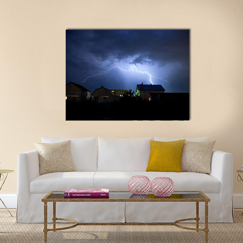 Dramatic Lightning Over Village at Night Canvas Wall Art in black, blue and navy, single panel hung on a wall
