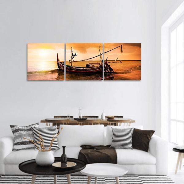 Local Boat on Beach at Sunset Panoramic Canvas Wall Art in brown, orange and yellow, hung on a wall