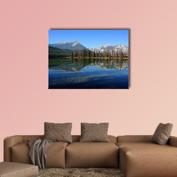 Lake and Sawtooth Mountain Canvas Wall Art in gray and blue, single panel hung on a wall