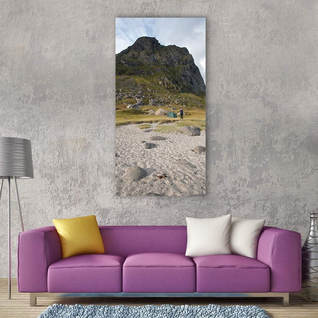 Mountain Beach with Tents and Lone Figure Vertical Canvas Wall Art in gray, beige and green, single vertical panel hung on a wall