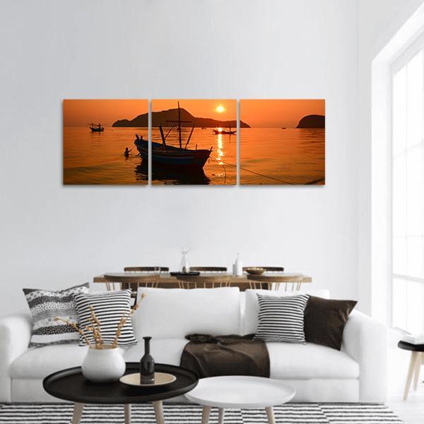 Long Tail Boat at Sunset Panoramic Canvas Wall Art in brown, orange and yellow, hung on a wall