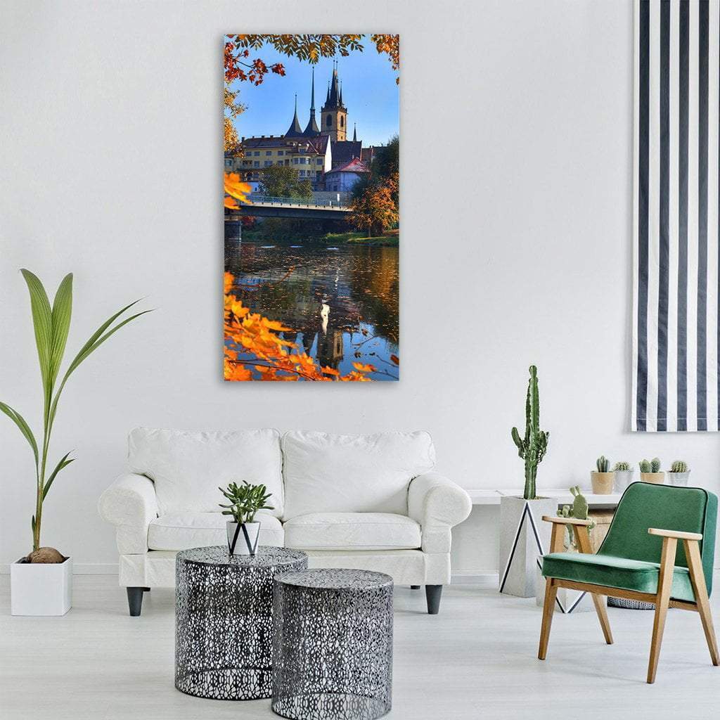 Louny Ohre River Autumn Reflection Vertical Canvas Wall Art in orange, yellow and blue, single vertical panel hung on a wall