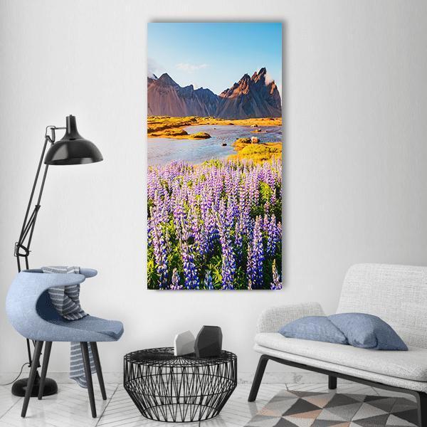 Majestic Lupine Flowers Vertical Canvas Wall Art in yellow, blue and purple, single vertical panel hung on a wall