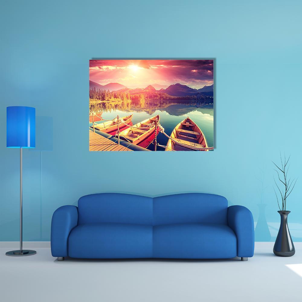 Three Canoes on Mountain Lake at Sunset Canvas Wall Art in orange, yellow and pink, single panel hung on a wall