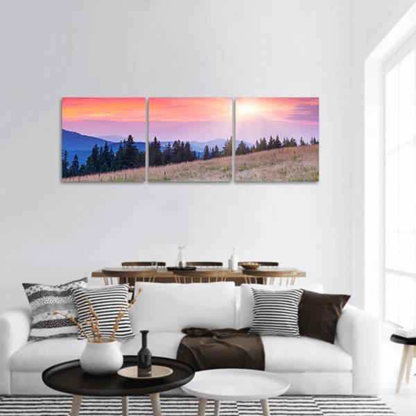 Sunset Over Majestic Mountain Range Panoramic Canvas Wall Art in orange, purple and pink, hung on a wall