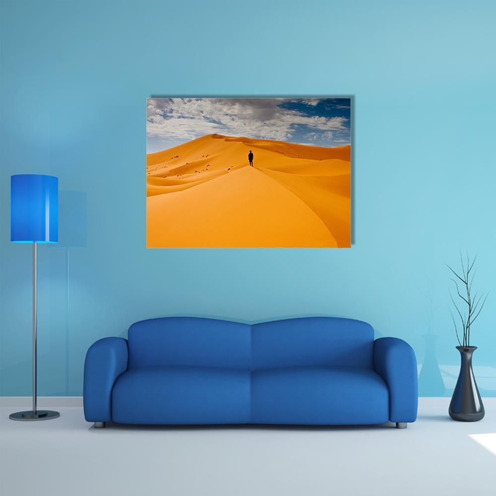 Lone Figure on Dune Crest Canvas Wall Art in orange, yellow and blue, single panel hung on a wall