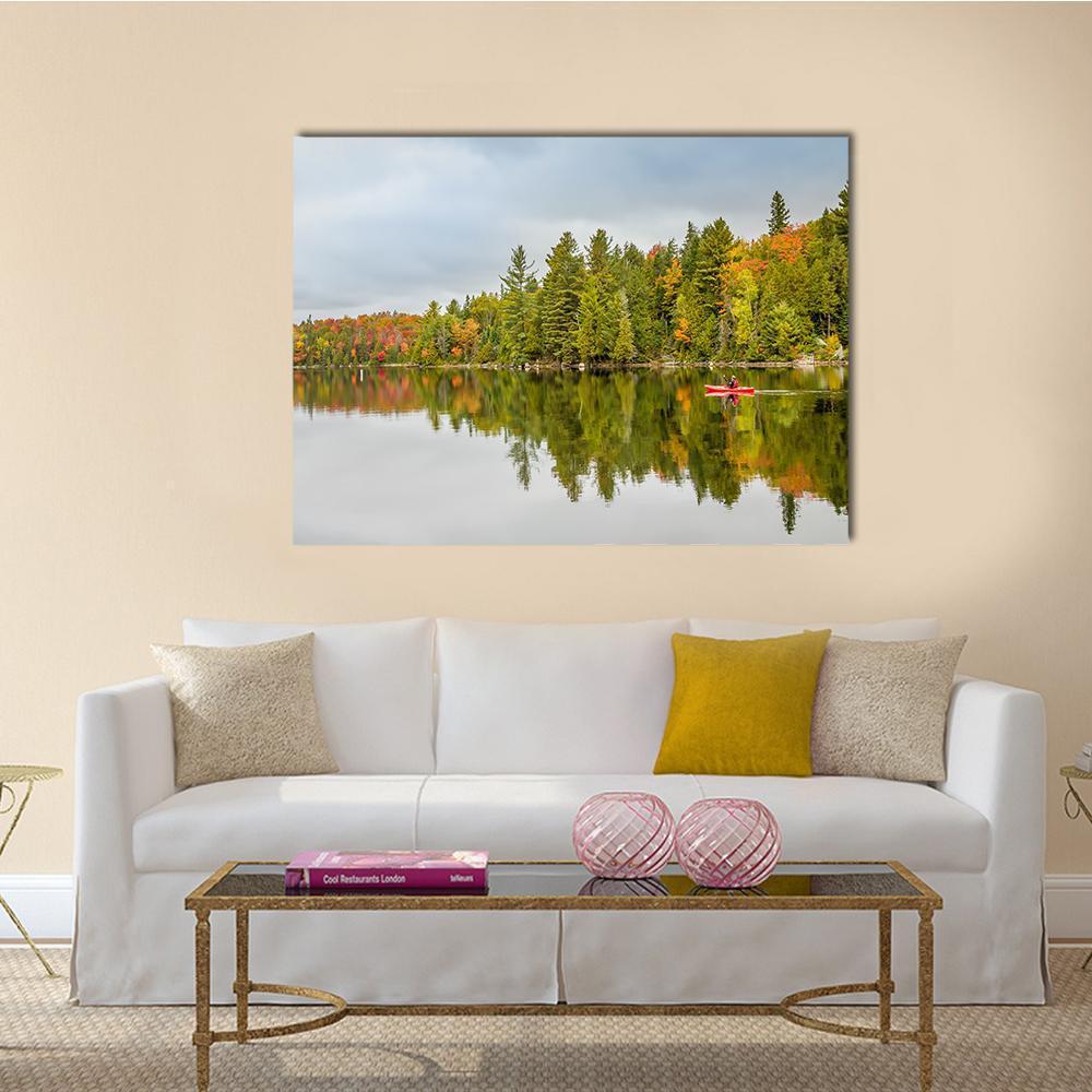 Man Paddling Red Kayak on Autumn Lake Canvas Wall Art in gray, orange and green, single panel hung on a wall