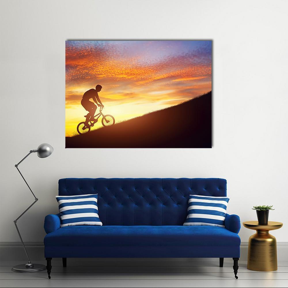 Bmx Rider Silhouette on Sunset Hill Canvas Wall Art in black, orange and yellow, single panel hung on a wall
