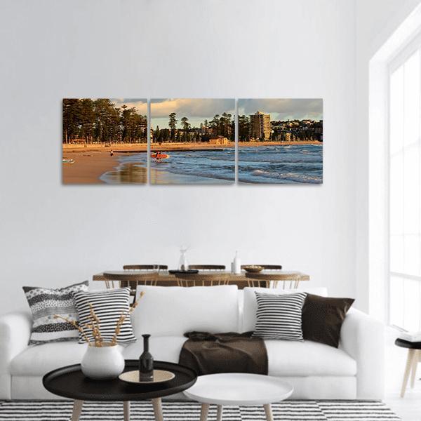 Manly Beach Surfer at Sunset Panoramic Canvas Wall Art in brown, orange and blue, hung on a wall