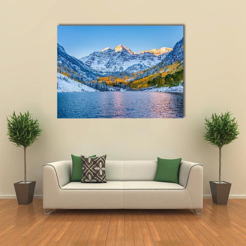 Maroon Bells at Serene Sunrise Canvas Wall Art in white, yellow and blue, single panel hung on a wall