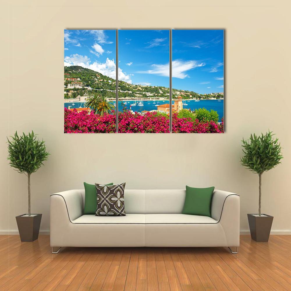 Mediterranean Coastal Town with Bougainvillea Canvas Wall Art in green, blue and pink, 3 panel horizontal set hung on a wall