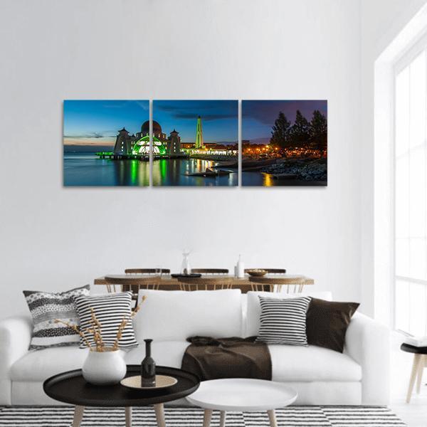 Melaka Straits Mosque Twilight Reflections Panoramic Canvas Wall Art in yellow, green and blue, hung on a wall