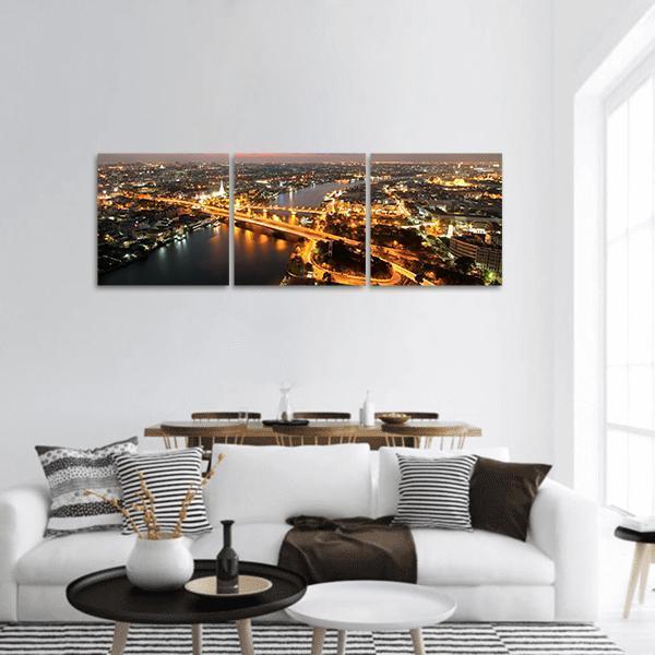 Illuminated Memorial Bridge Night Skyline Thailand Panoramic Canvas Wall Art in black, gold and yellow, hung on a wall