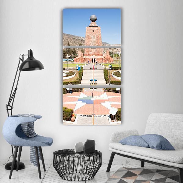 Mitad Del Mundo Monument, Ecuador Vertical Canvas Wall Art in beige, brown and blue, hung on a wall
