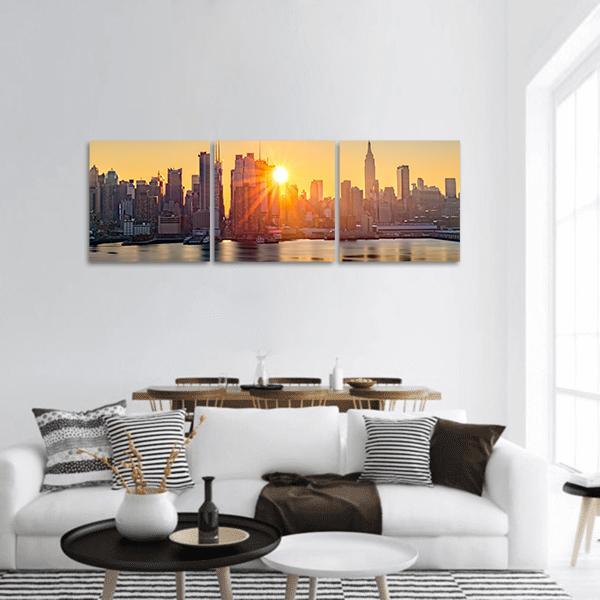 Manhattan Skyline at Sunset Panoramic Canvas Wall Art in gray, orange and yellow, hung on a wall
