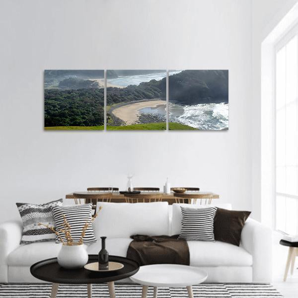 Misty Beach with Coastal Cliffs Panoramic Canvas Wall Art in gray, green and blue, hung on a wall