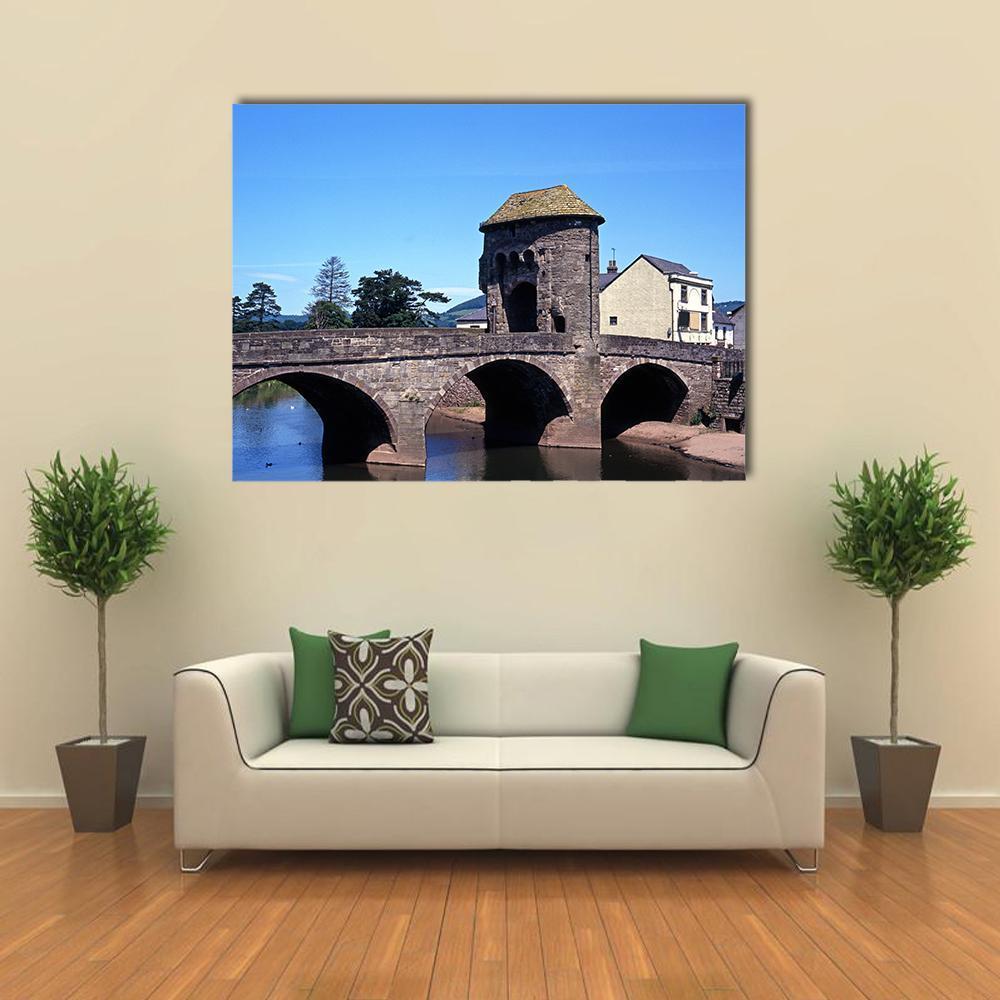 Monnow Bridge and Gatehouse Canvas Wall Art in gray, brown and blue, single panel hung on a wall