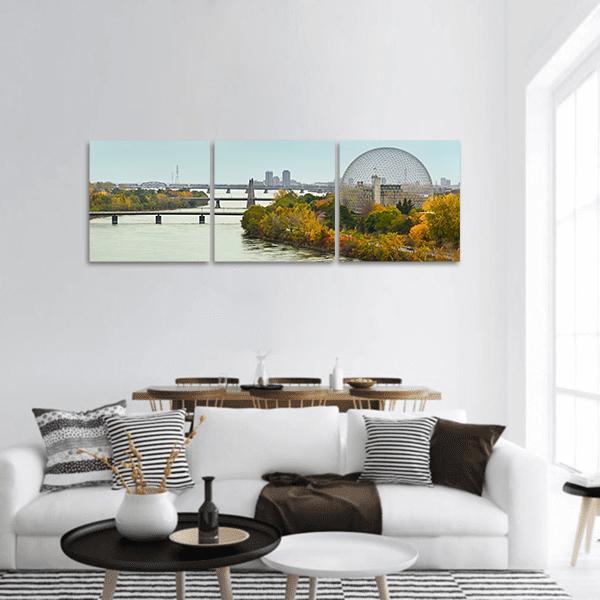 Montreal Bridges in Autumn Panoramic Canvas Wall Art in yellow, green and blue, hung on a wall