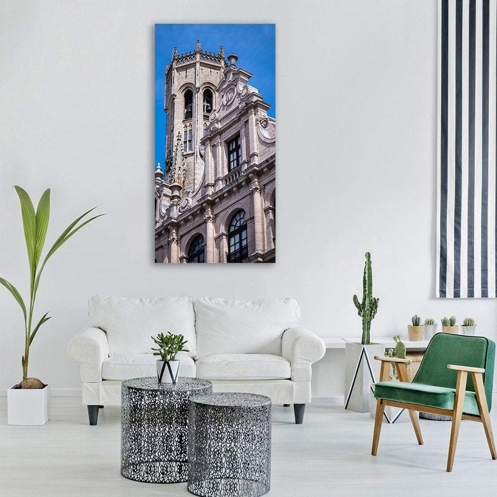 Monument of Bruges Vertical Canvas Wall Art in gray, beige and blue, single vertical panel hung on a wall