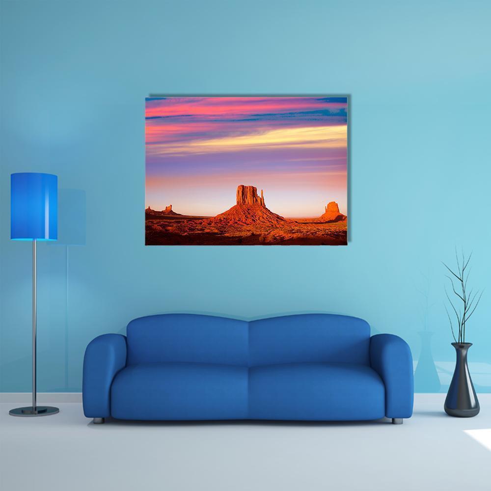 Monument Valley at Sunset Canvas Wall Art in orange, purple and pink, single panel hung on a wall