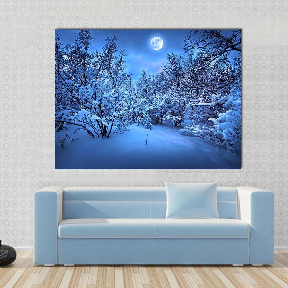 Moonlit Path Through Snowy Forest Canvas Wall Art in white and blue, single panel hung on a wall