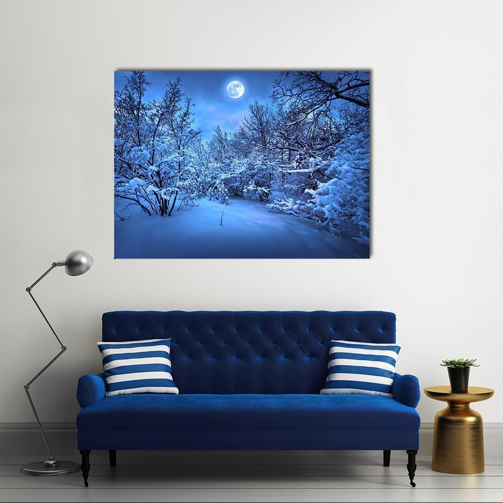 Moonlight Over Snowy Forest Canvas Wall Art in white and blue, single panel hung on a wall