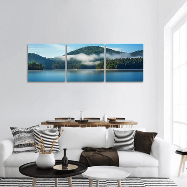 Misty Mountain Lake with Pines Panoramic Canvas Wall Art in white, green and blue, hung on a wall
