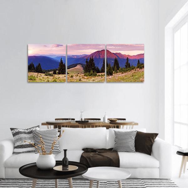 Glowing Mountain Valley at Dawn Panoramic Canvas Wall Art in blue, purple and pink, hung on a wall