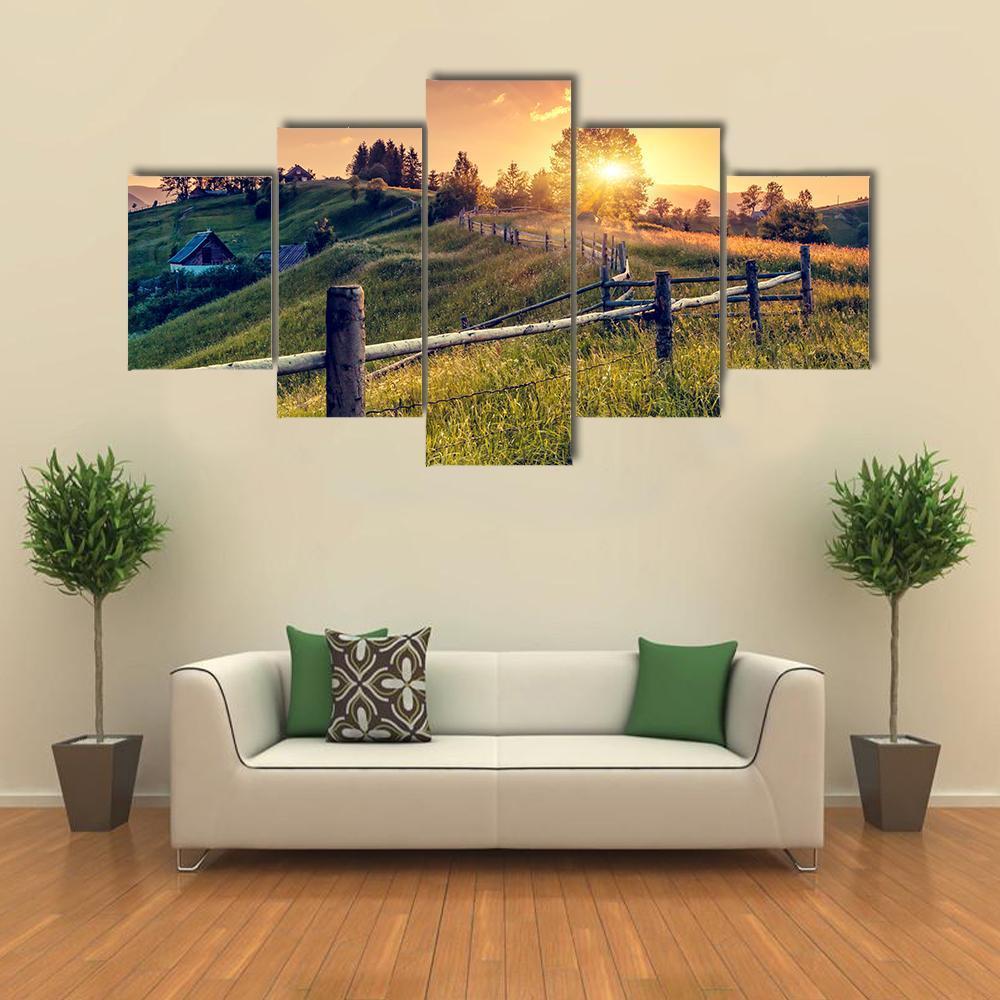 Sunset Farmhouse with Wooden Fence Canvas Wall Art in orange, yellow and green, 5 panel Pop layout hung on a wall