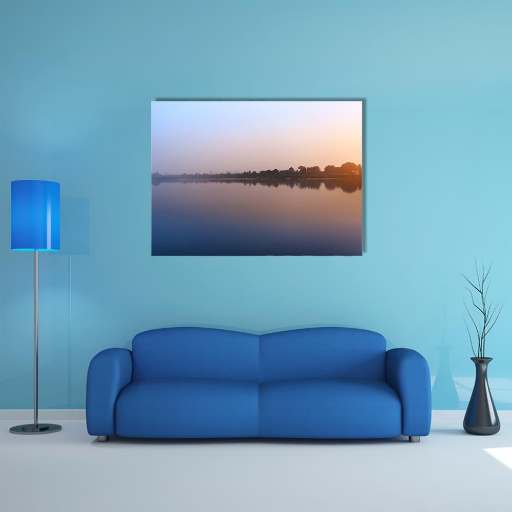 Ganga River Morning Canvas Wall Art in orange, yellow and blue, single panel hung on a wall