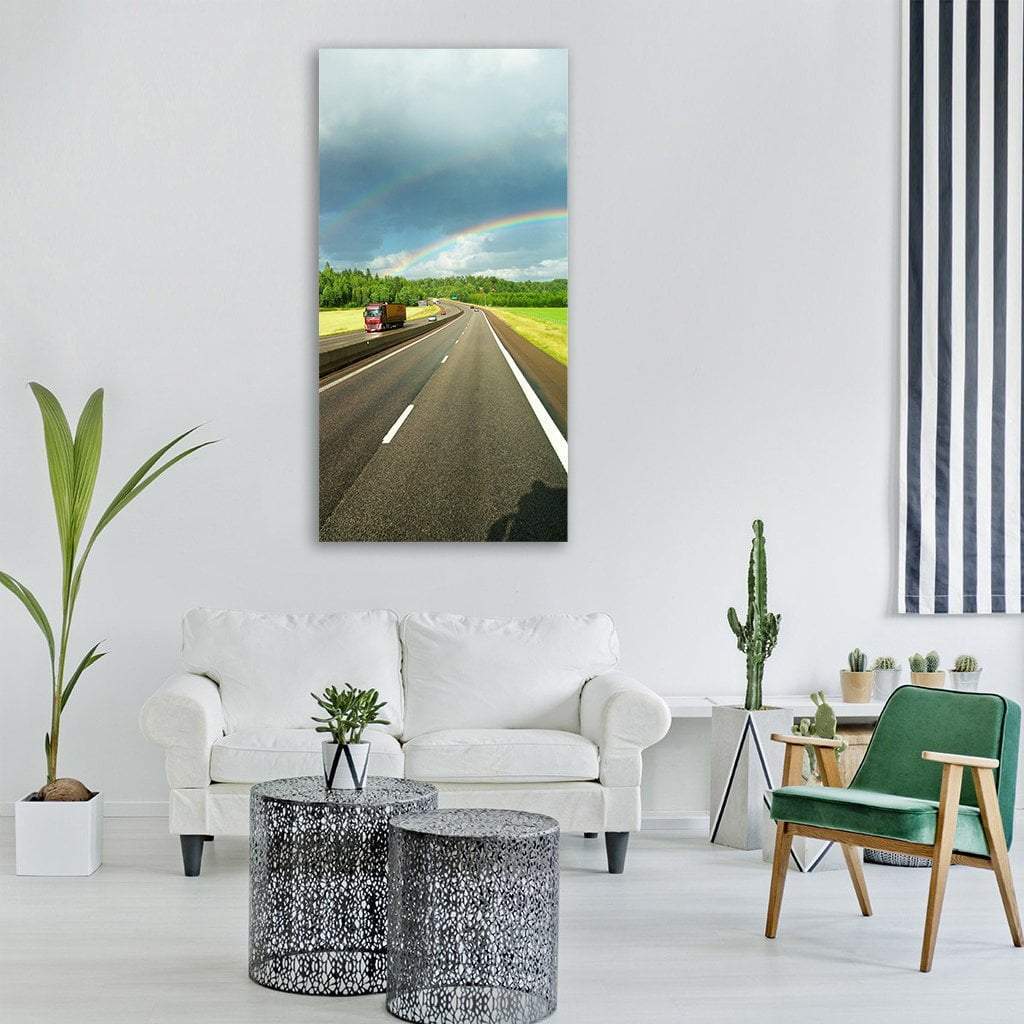 Motorway with Red Truck and Double Rainbow Vertical Canvas Wall Art in gray, green and blue, single vertical panel hung on a wall