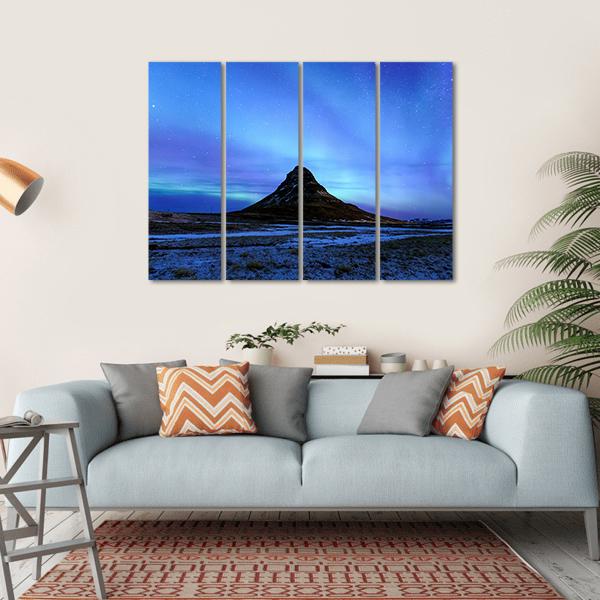 Kirkjufell Mountain and Aurora Borealis Canvas Wall Art in black, blue and purple, hung on a wall