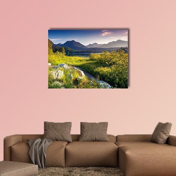 Mountain Lake with Rocky Foreground Canvas Wall Art in yellow, green and blue, single panel hung on a wall