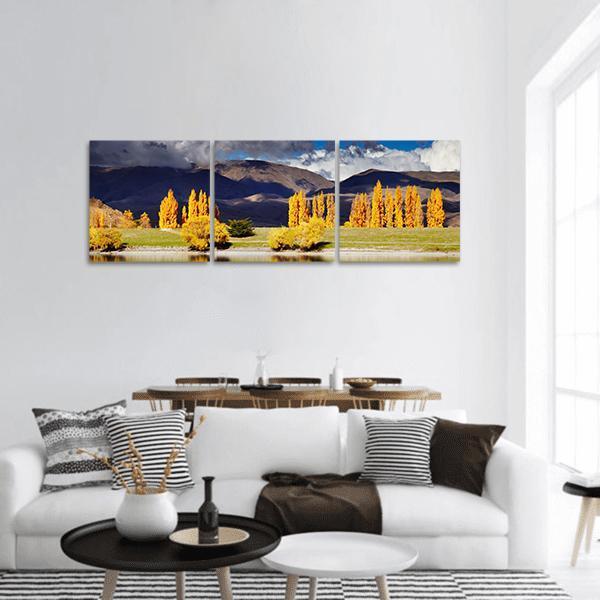 Lake Benmore in Autumn Panoramic Canvas Wall Art in brown, yellow and blue, hung on a wall