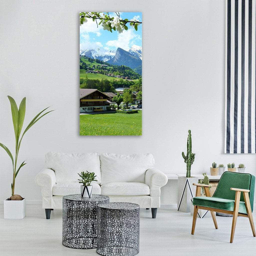 Alpine Village with Spring Blossoms Vertical Canvas Wall Art in white, green and blue, hung on a wall