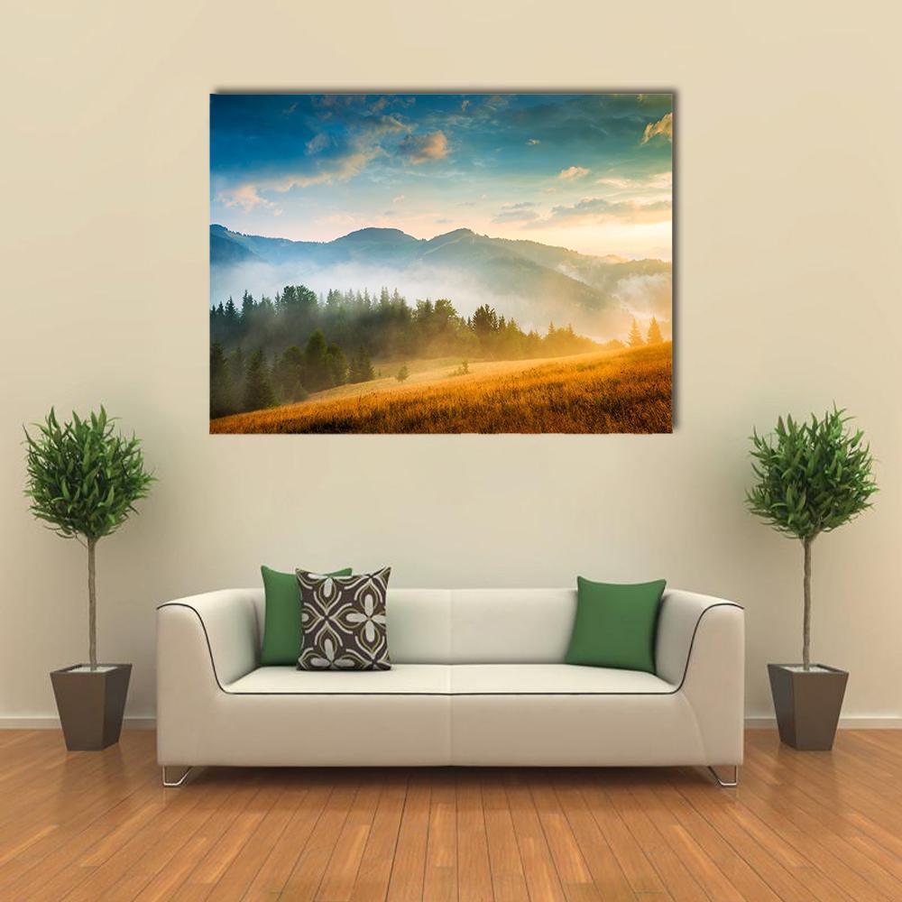 Misty Mountain Landscape at Sunset Canvas Wall Art in orange, yellow and blue, single panel hung on a wall