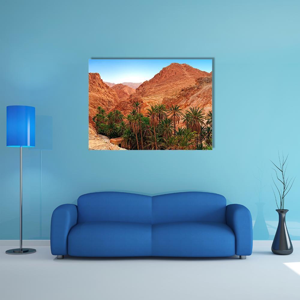 Desert Oasis with Palm Trees Canvas Wall Art in brown, orange and green, single panel hung on a wall