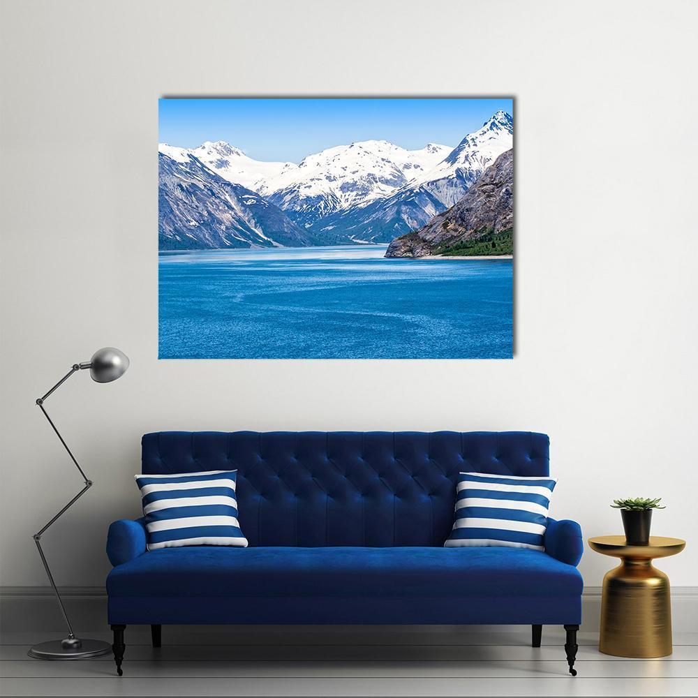 Snow-capped Mountains Over Calm Blue Water Canvas Wall Art in white, gray and blue, single panel hung on a wall