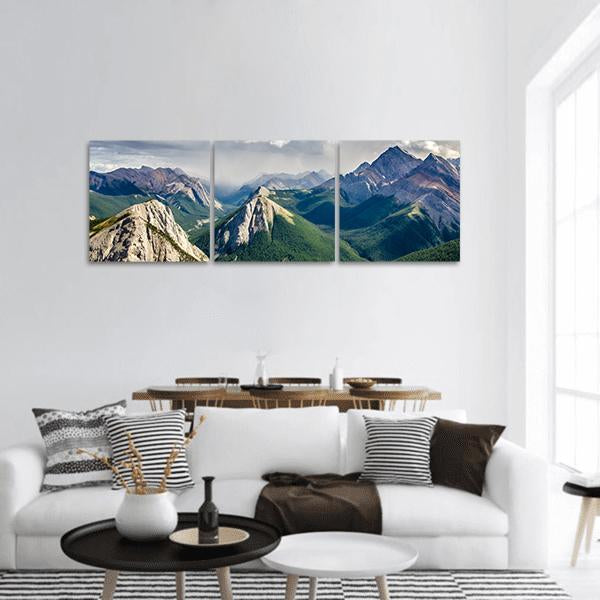 Misty Peaks in the Canadian Rockies Panoramic Canvas Wall Art in gray, green and blue, hung on a wall
